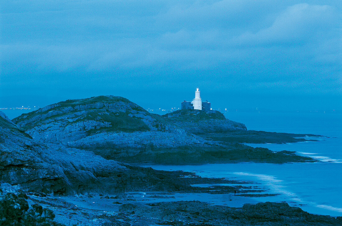 View of Lighthouse, rocky coast at night