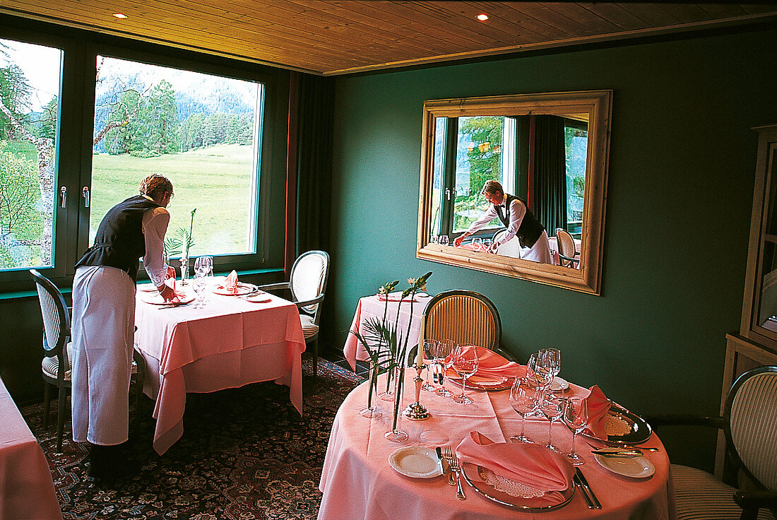 Ein Kellner deckt Tische im feinen Gourmet-Restaurant "La Bellezza"
