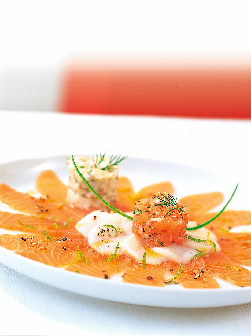 Carpaccio von Jakobsmuscheln und Lachs, dekoriert mit Muscheltatar