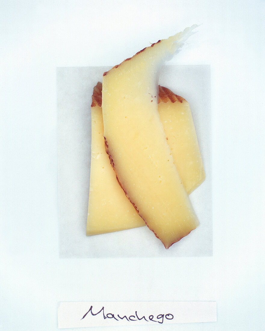 Manchego slices on white surface