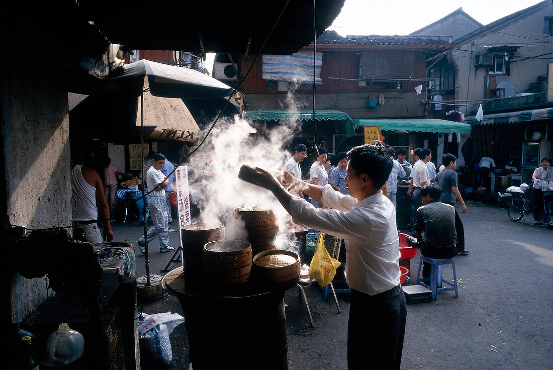 Garküche mit dampfenden Töpfen auf einer Straße in Shanghai