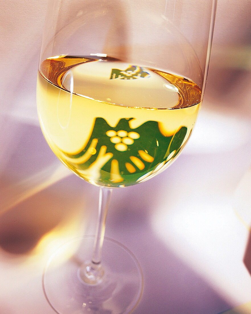 Glas mit Weißwein, in dem sich das Logo des VDP spiegelt