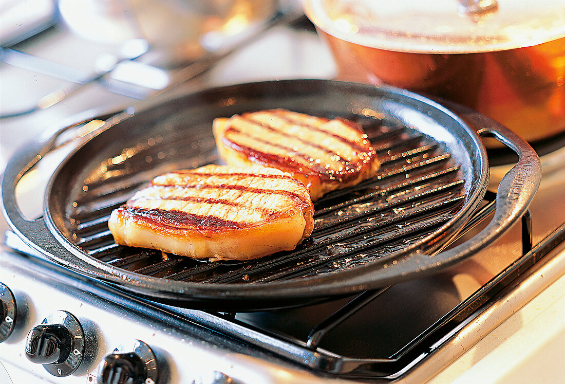 Schweinesteaks auf einer Grillpfanne 