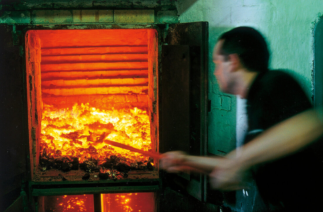 Mälzer heizt den Ofen fürs Trocknen der Gerste: Whiskyproduktion