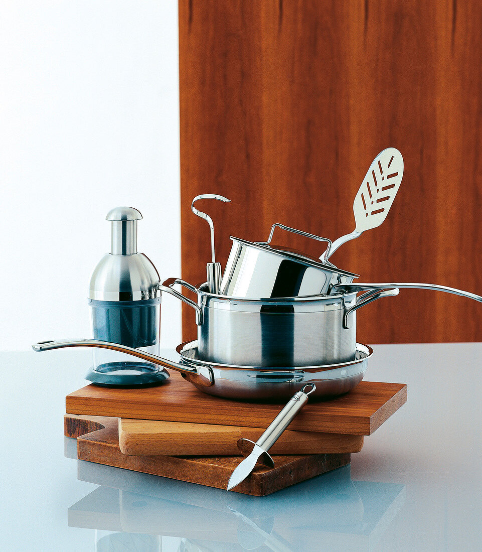 Stacked pots and cooking utensils on chopping boards