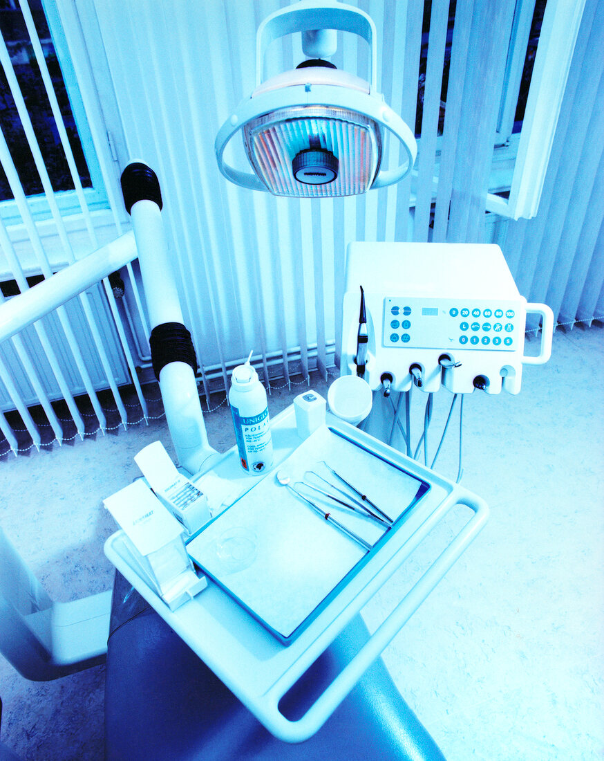 Elevated view of dentist's chair and equipments at dental clinic, toned image