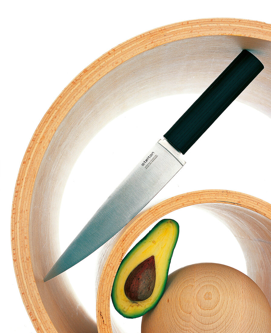 Das Design-Kochmesser von "Stelton", eine Holzschale, eine Südfrucht