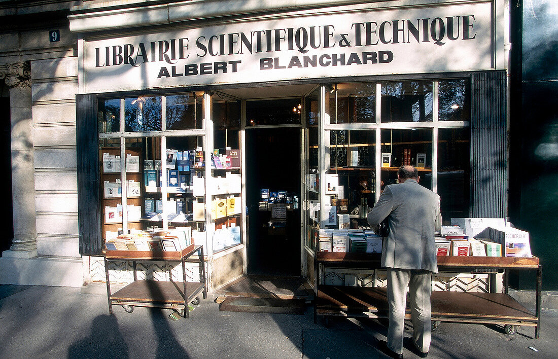 Customer buying books outside Library Albert Blanchard in Paris, France