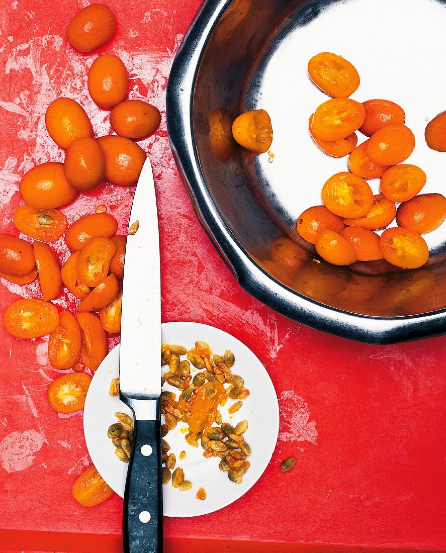 Kumquats being blanched, halved and pitted
