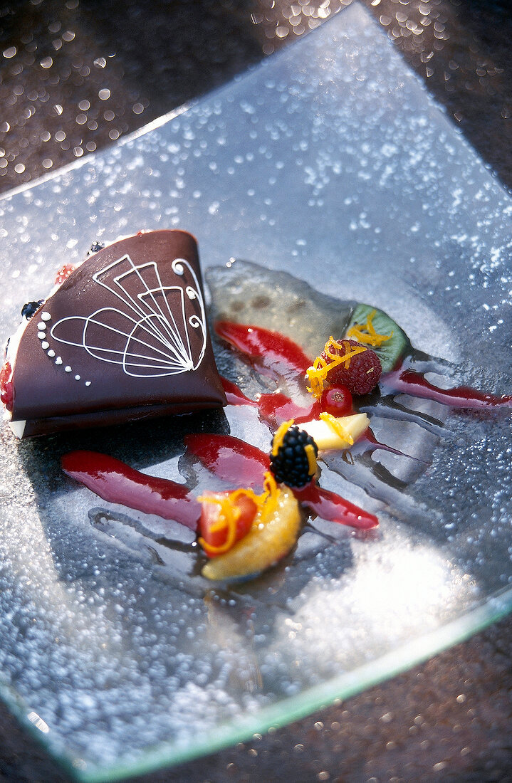 Close-up of chocolate cake with fruits on glass plate