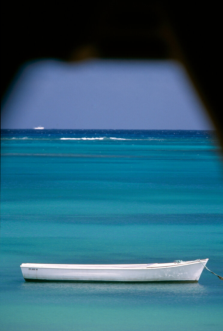 Weiter Blick über das Meer mit weißem Ruderboot vor Mauritius