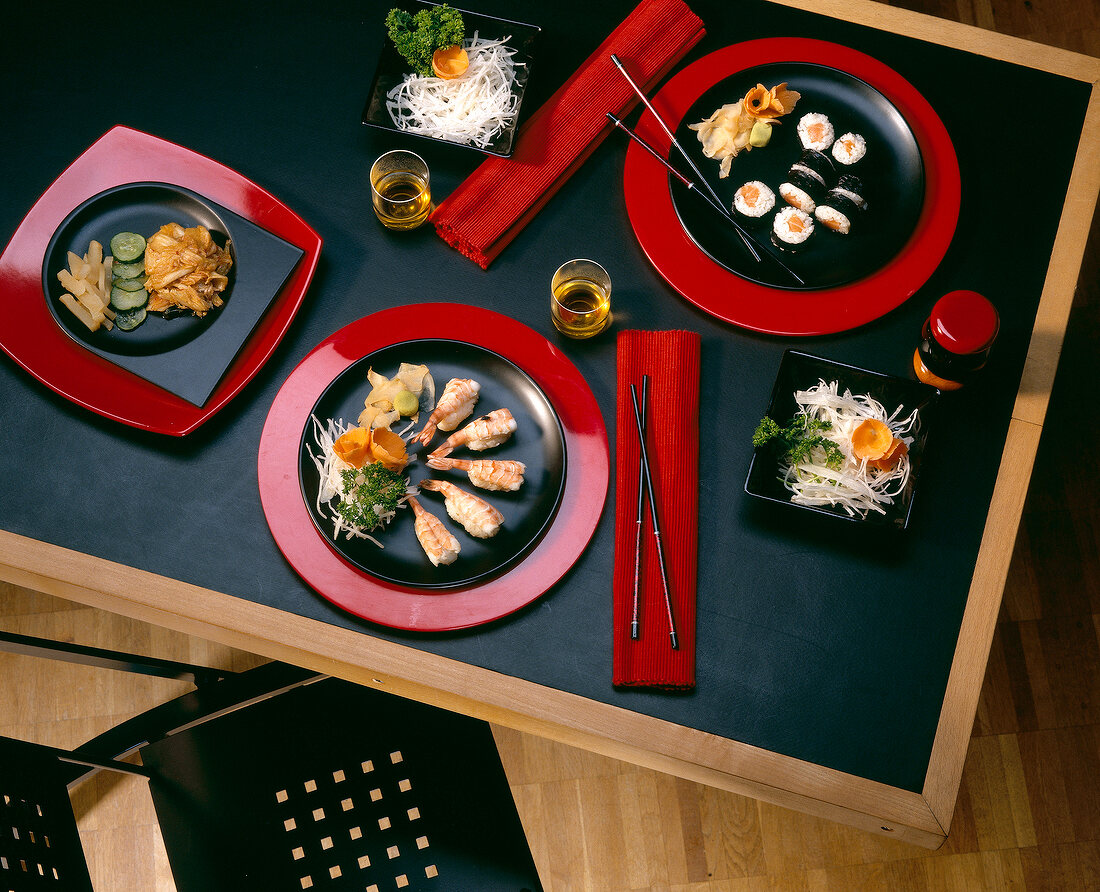 Set table with sushi on plates, overhead view