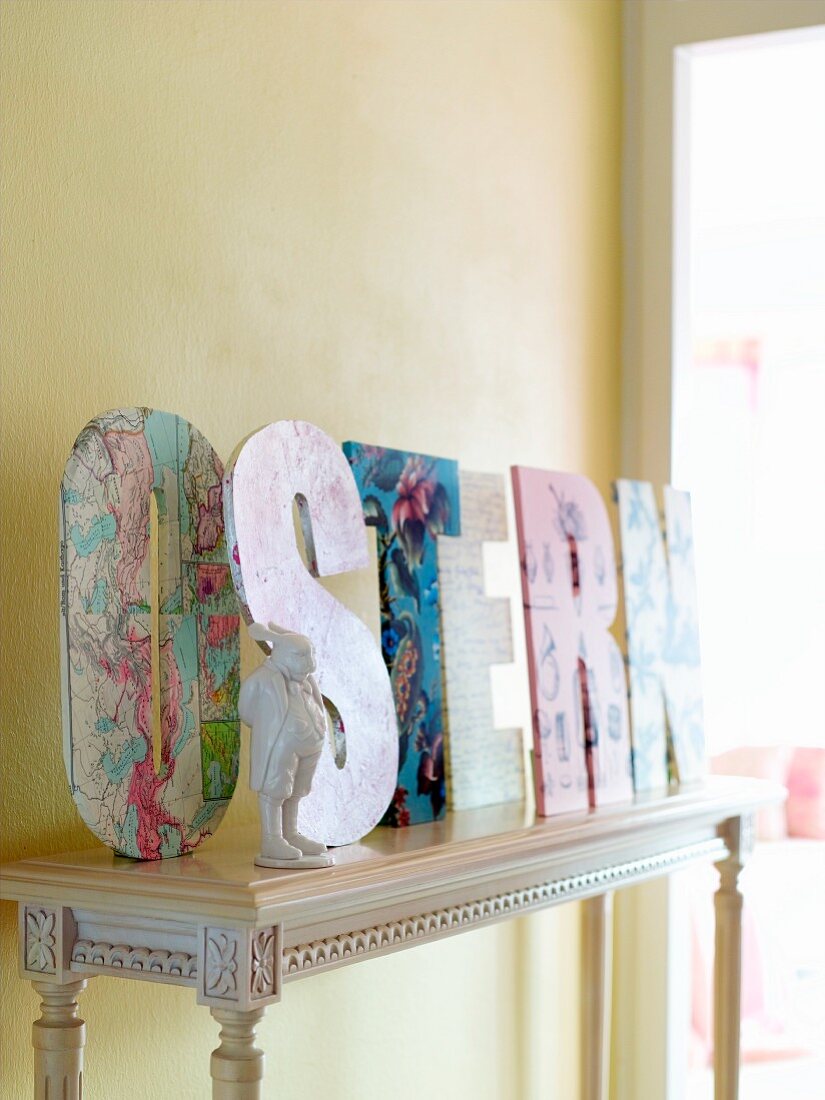 The word 'Ostern' (German: Easter) in decorative letters on a console table