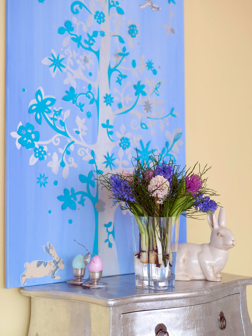 Easter decoration on silver table with drawer and floral painting on wall