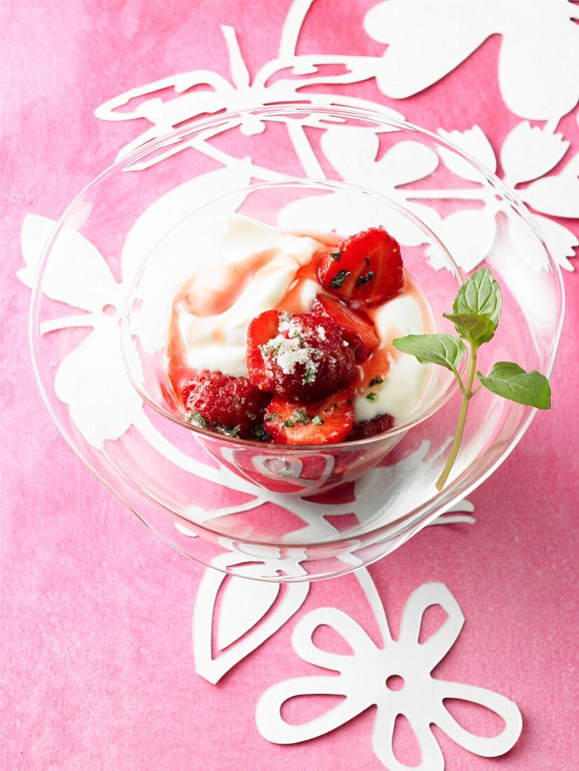 Eine Glasschale Erdbeer-Jogurt mit Rhabarber-Sirup