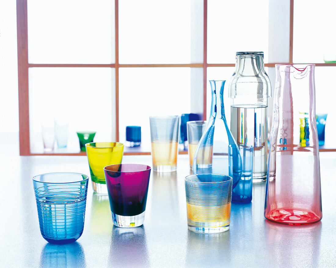 Colourful glasses, goblets and decanters on floor