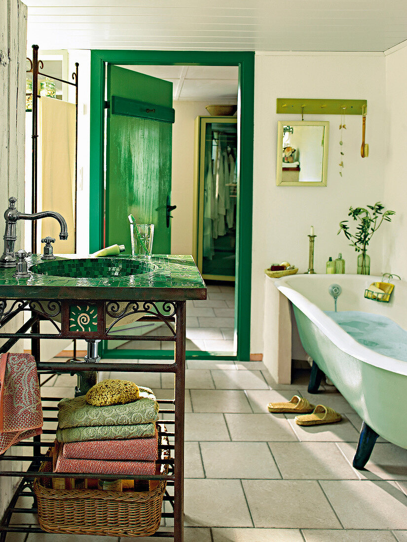 Bathroom with green mosaic table and terracotta stones flooring
