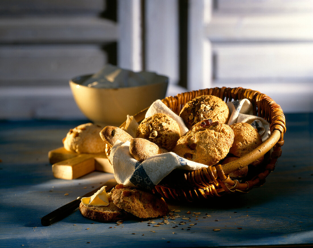 Spelled bread with raisins and potato rolls in wicker basket