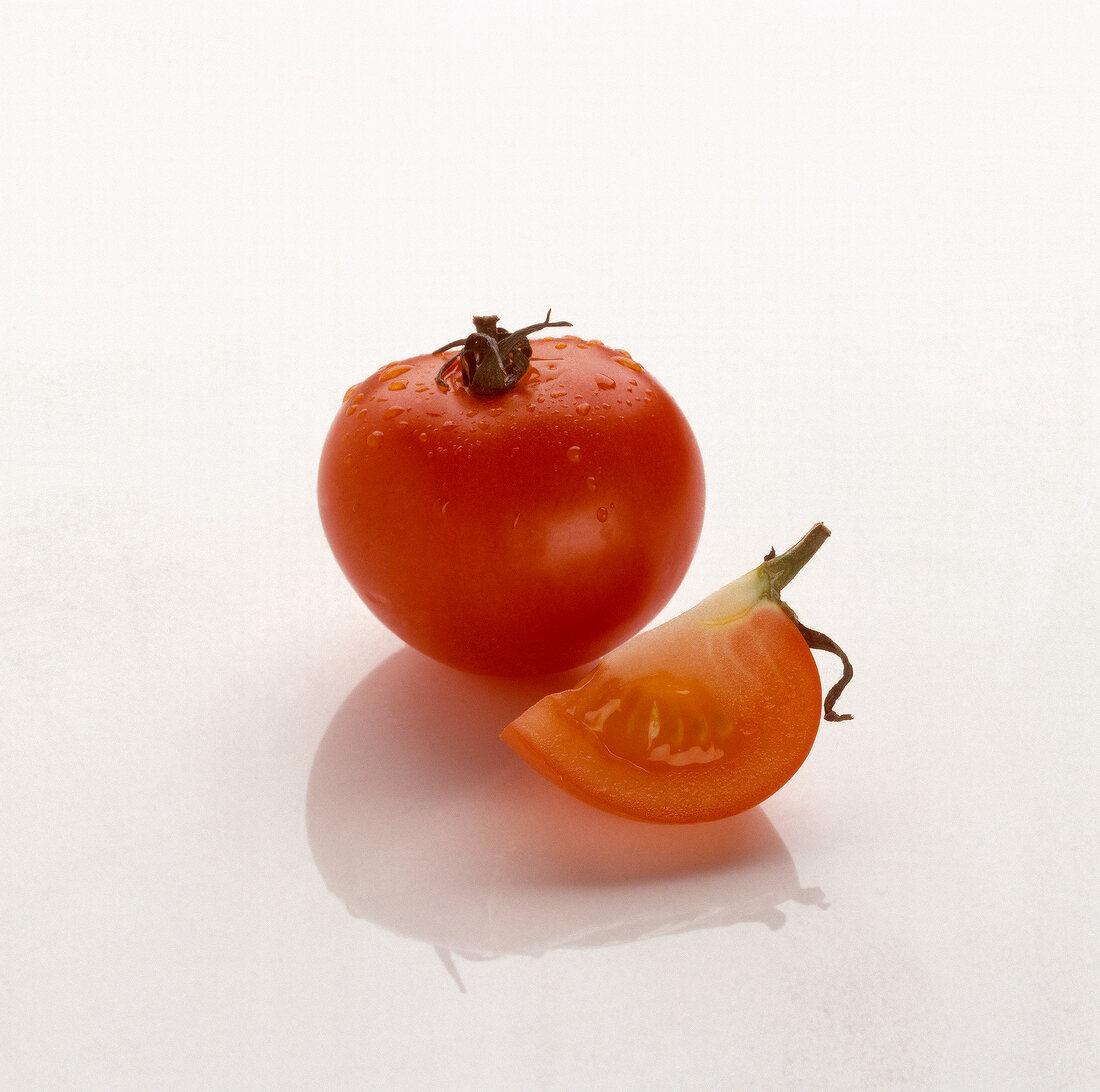 Sliced and whole fresh tomato on white background