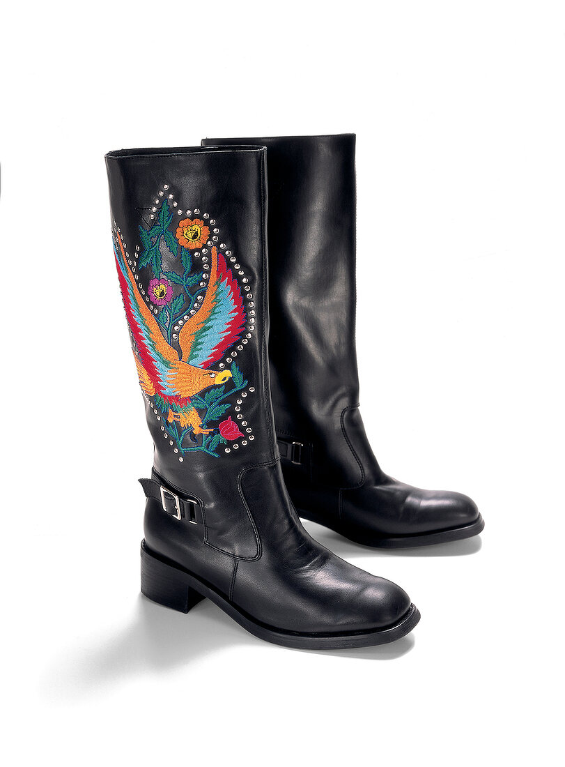 Black boots with eagle ornamental embroidery on white background