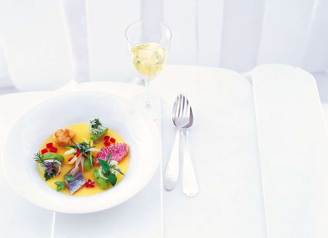 Jellied soup with red mullet, herring and scallops on plate