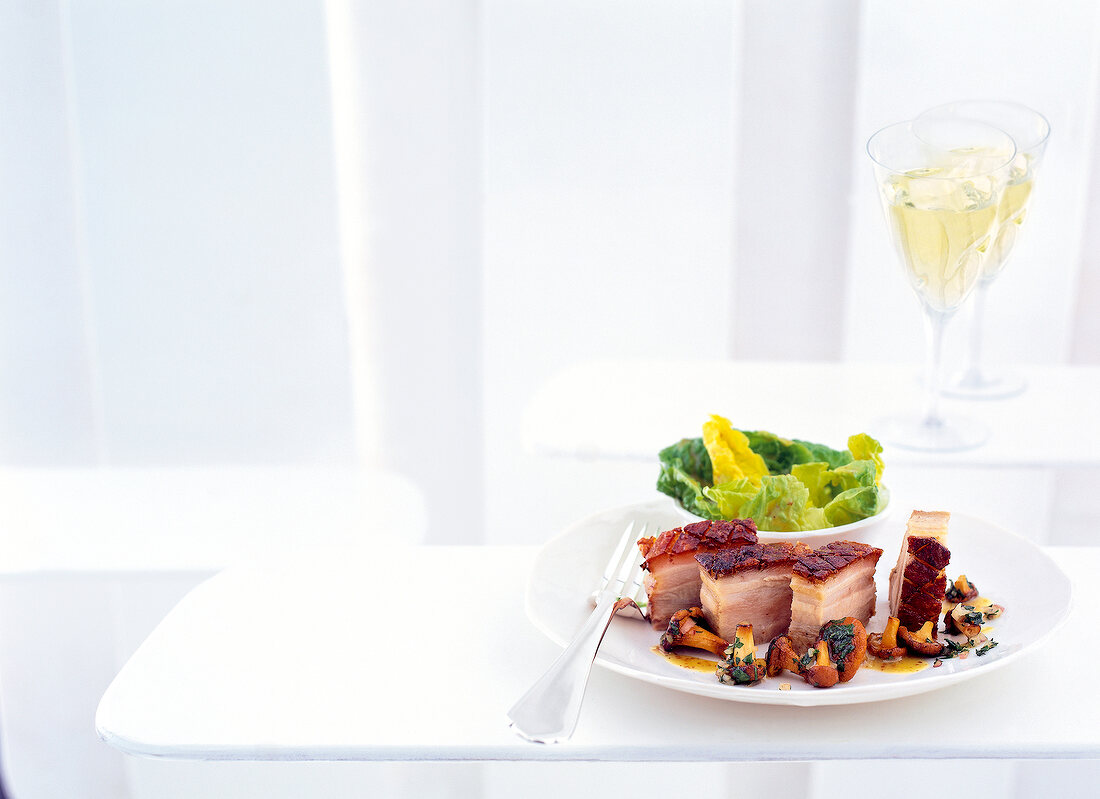 Pork belly with fried mushrooms on plate