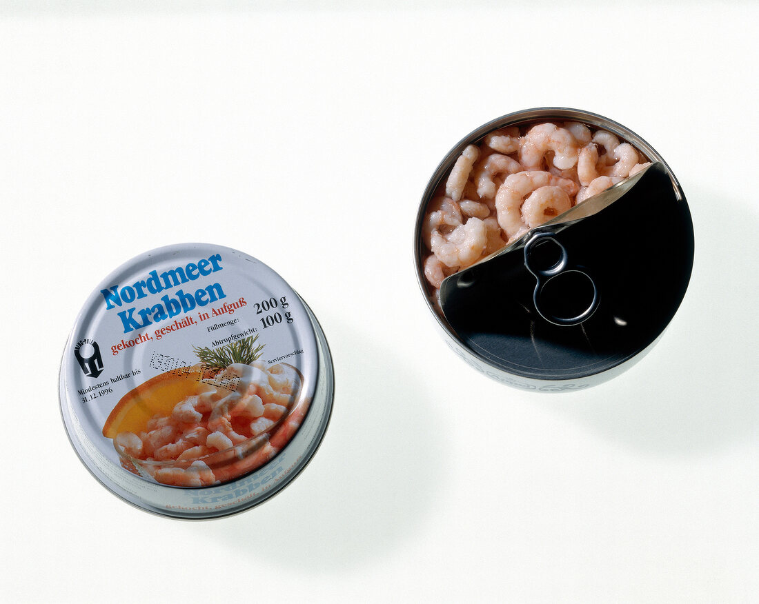 Opened tin with north sea shrimps on white background