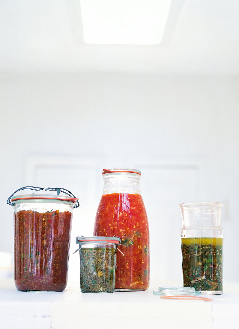Different types of pasta sauce in four glass jars