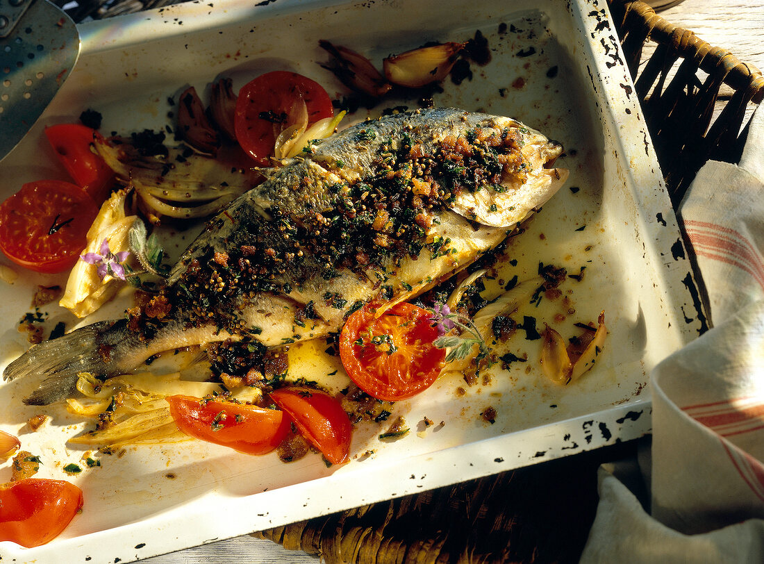 Roasted sparidae with vegetables on baking tray