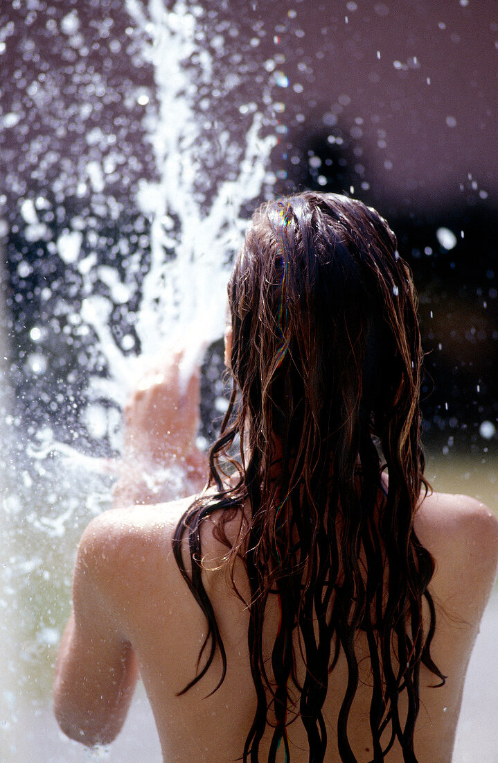 Rear view of woman with long hair under shower