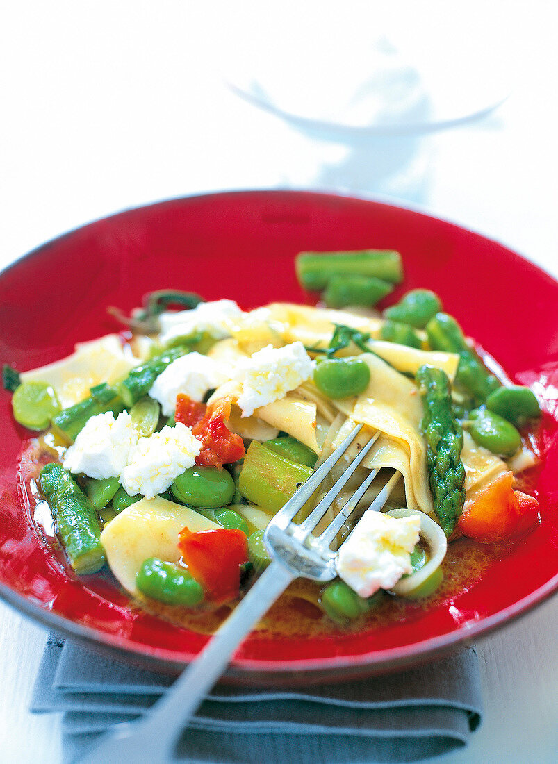 Pasta with peas, asparagus and cheese served on plate