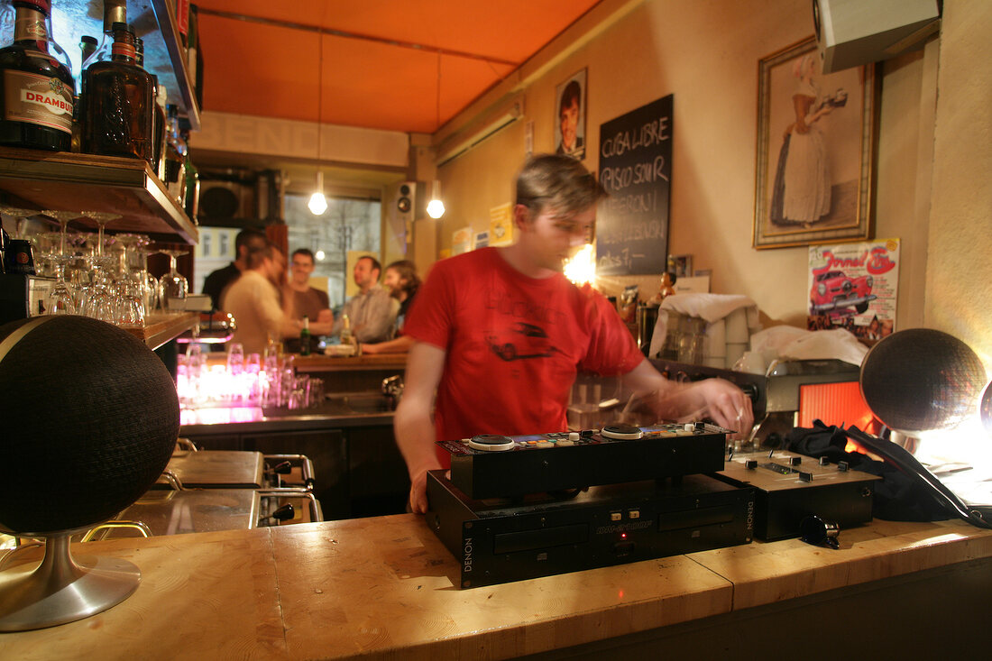 Disc jockey playing music in restaurant, Germany