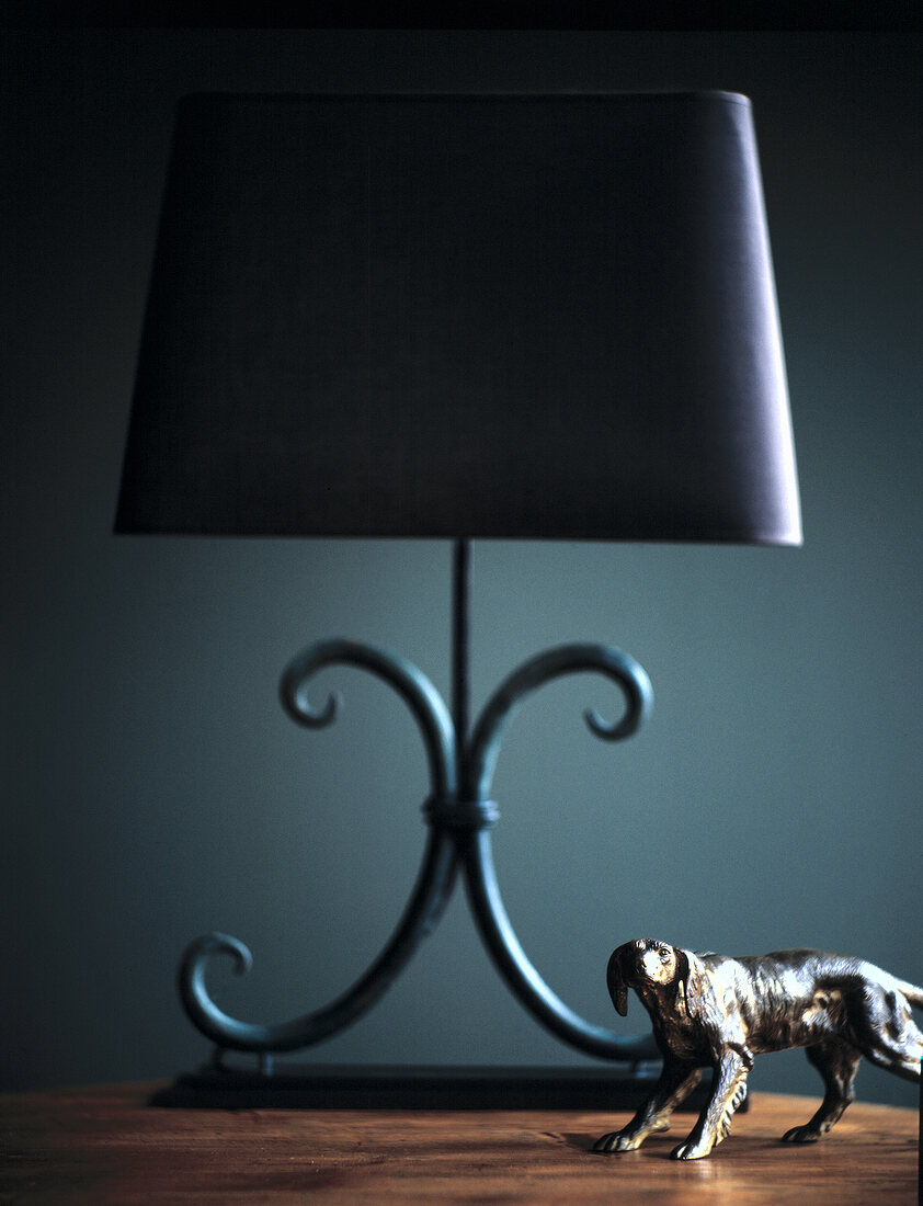 Metal lamp with blue lampshade and animal figurine on table