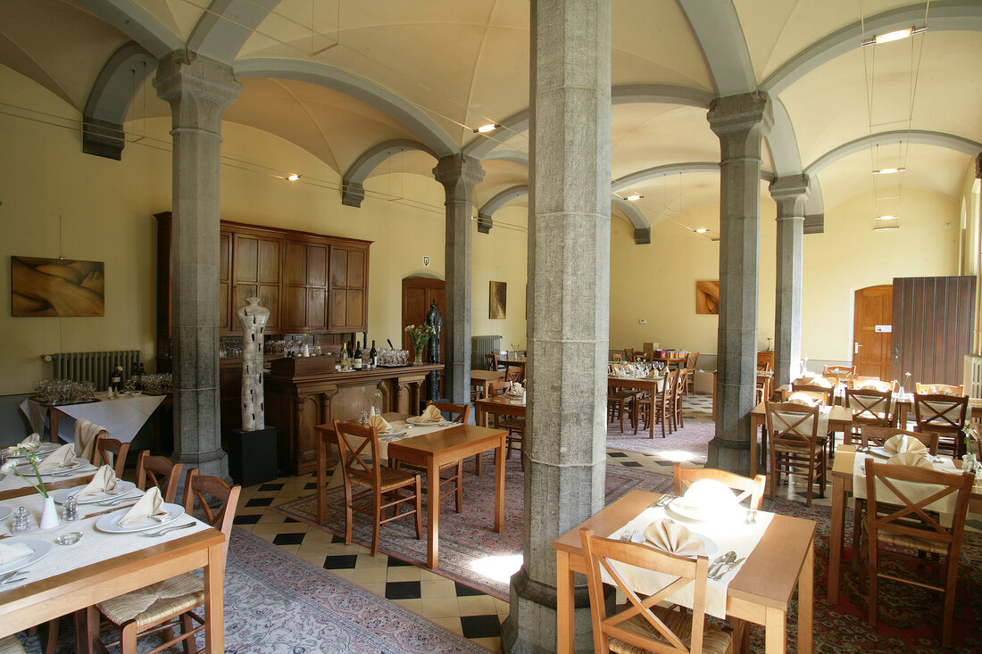 Laid dining tables and columns in hotel, Belgium