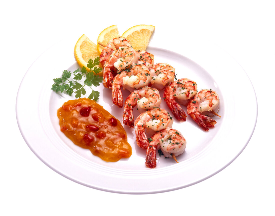 Szechuan shrimp skewers with sauce on plate