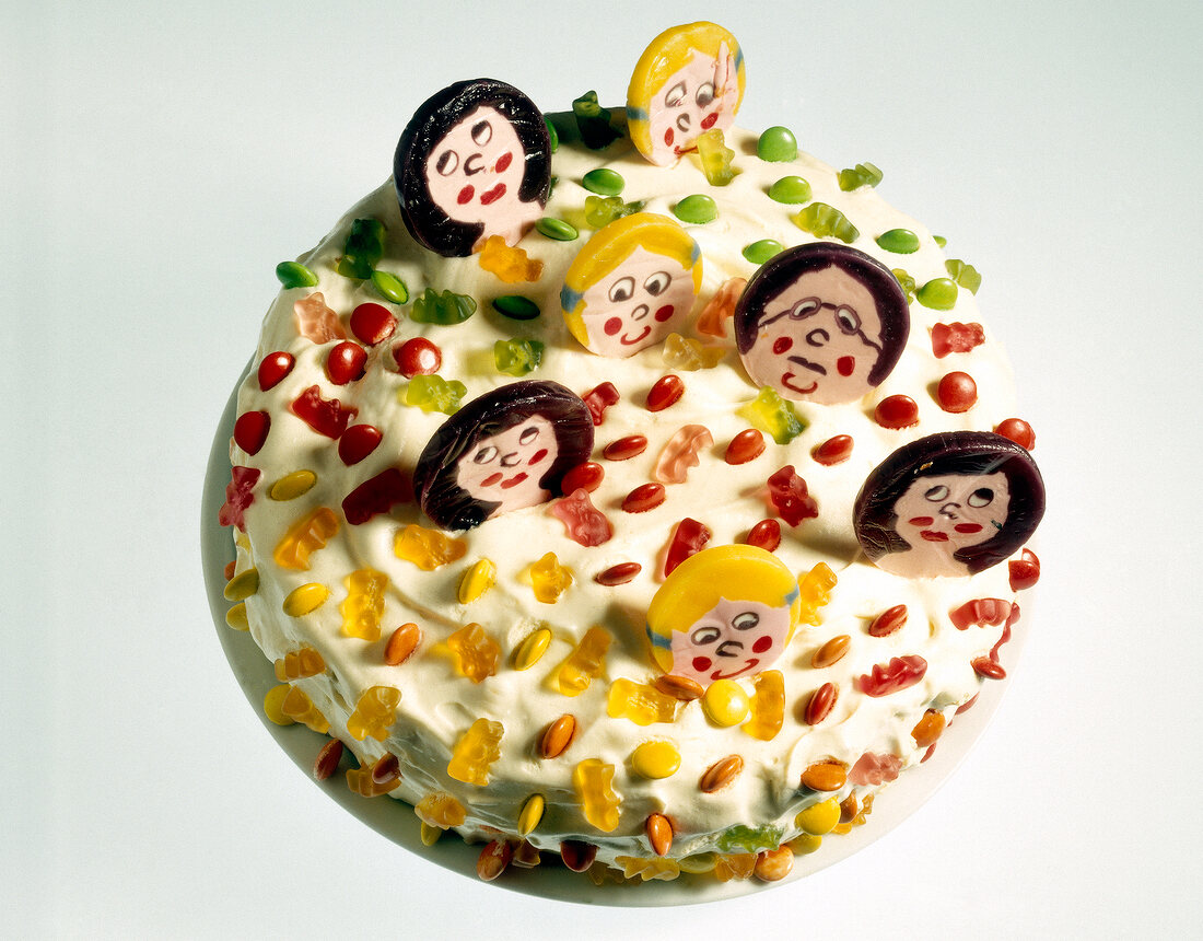 Close-up of cake with nuts and human face shaped candies