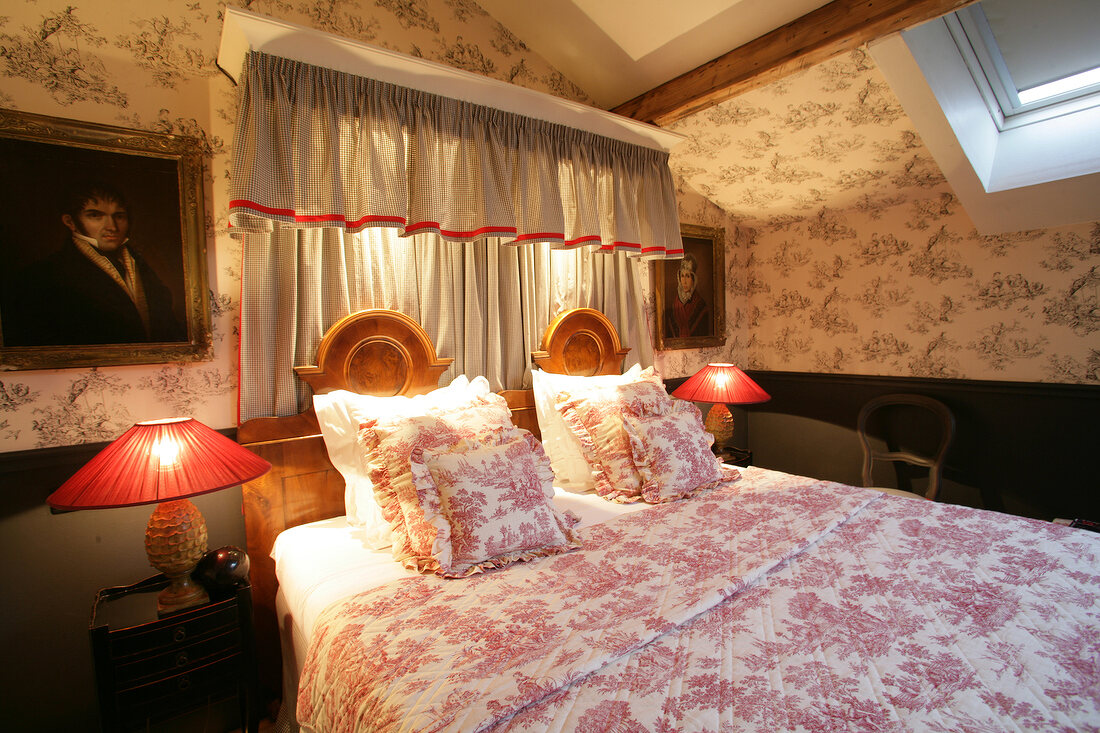 View of luxurious hotel bedroom with double bed against patterned wallpaper, Belgium