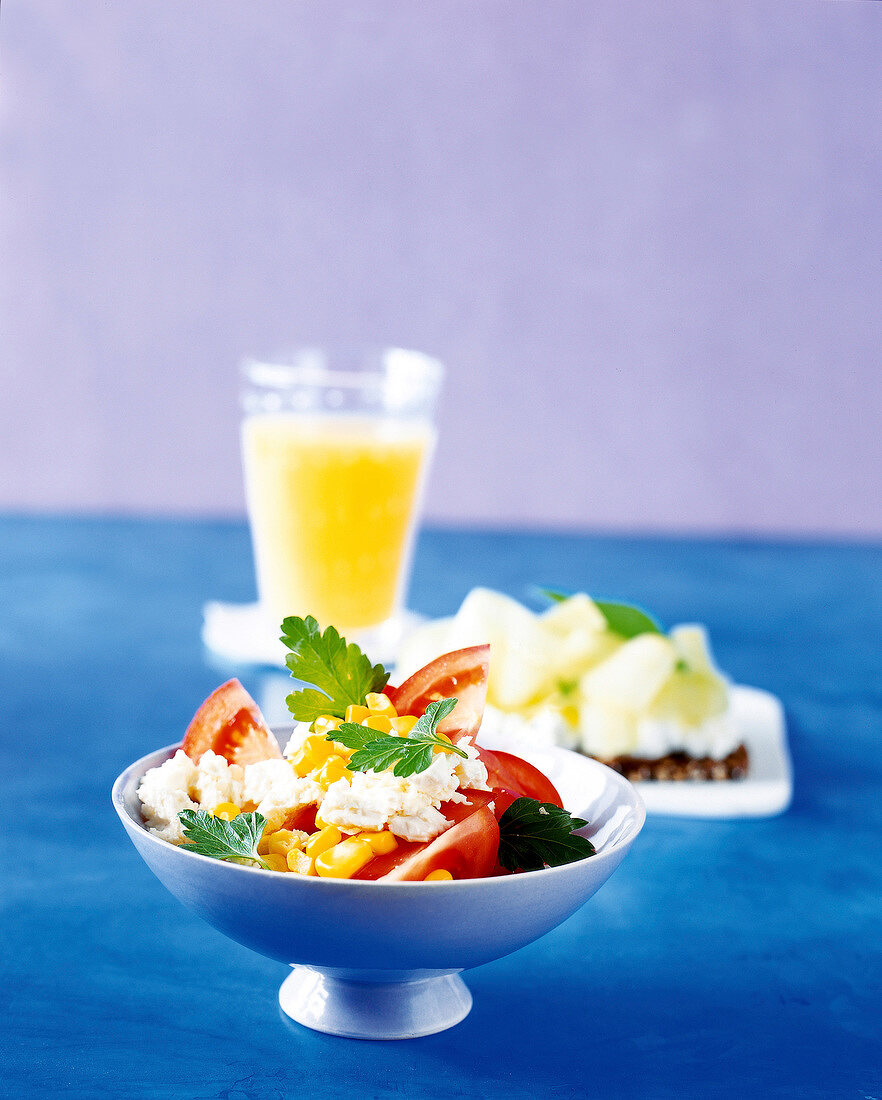 Tomato and corn salad with cheese in bowl