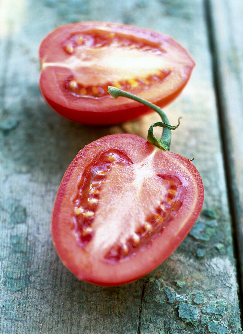 Close-up of two halves of tomatoes on wooden surface