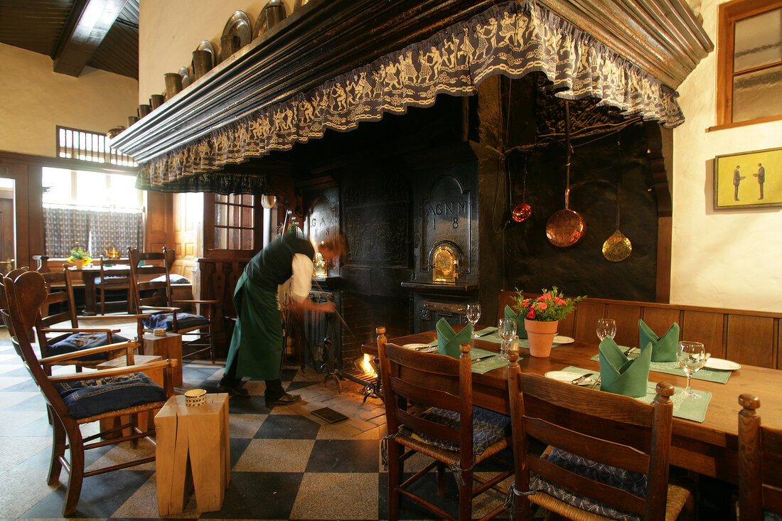 Man at fireplace of restaurant in hotel