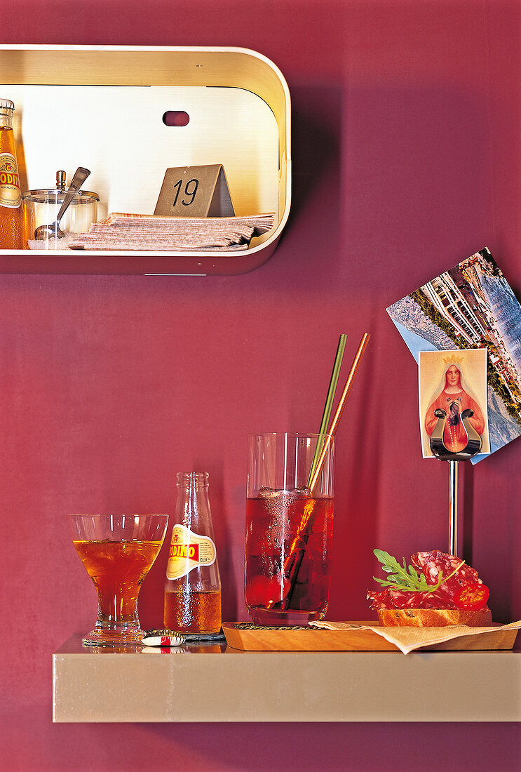 Negroni cocktail, wine and crostini with fennel salami on table