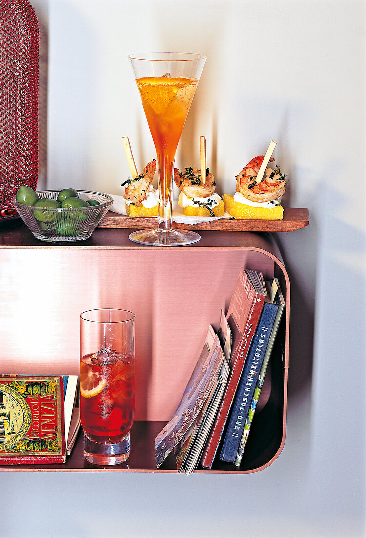 Aperol Spritz, Venetian Spritz, polenta with ricotta and king prawns on book shelf