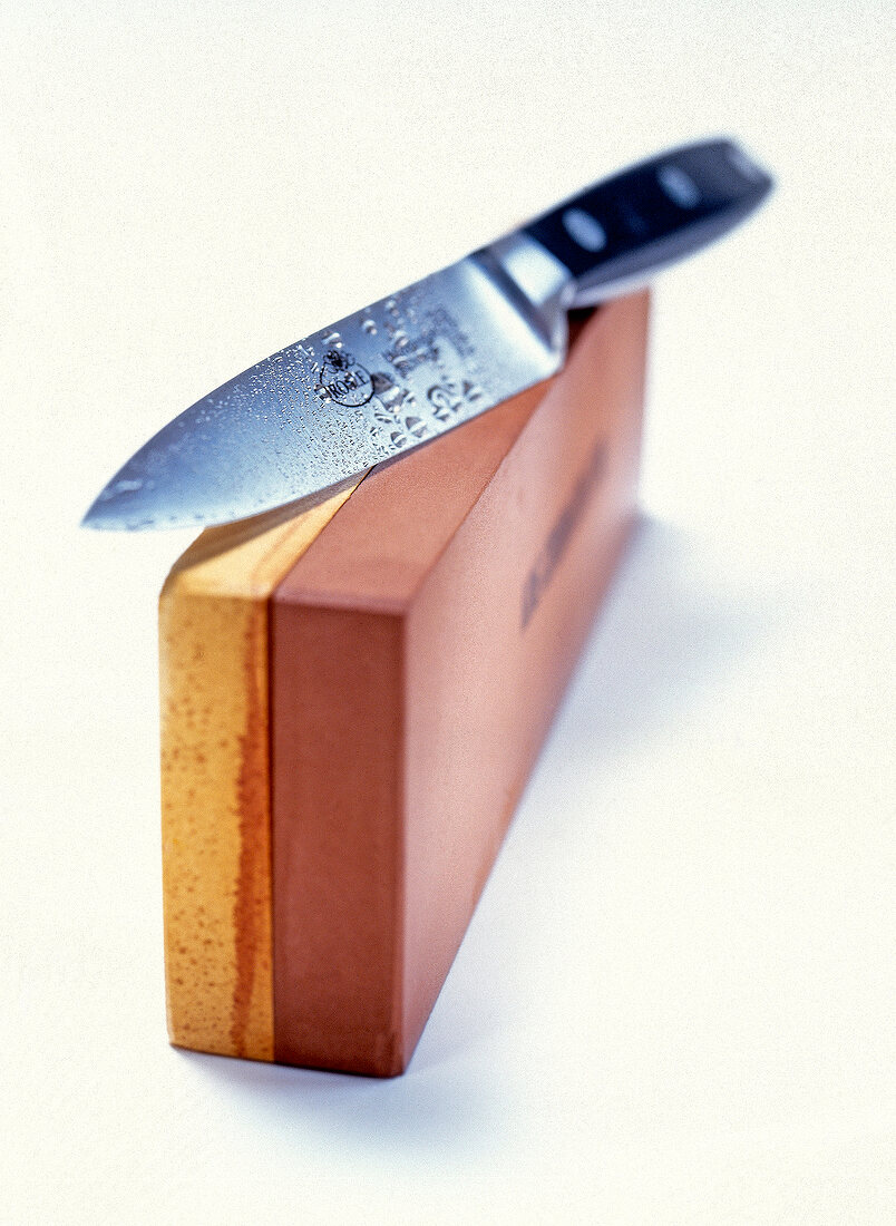 Sharp knife and box on white background