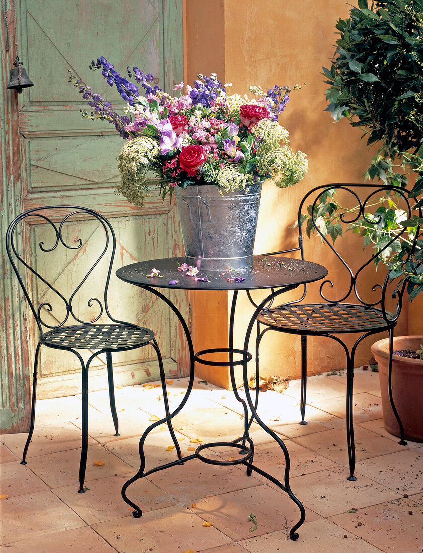 Garden terrace with chairs and table made of black painted iron
