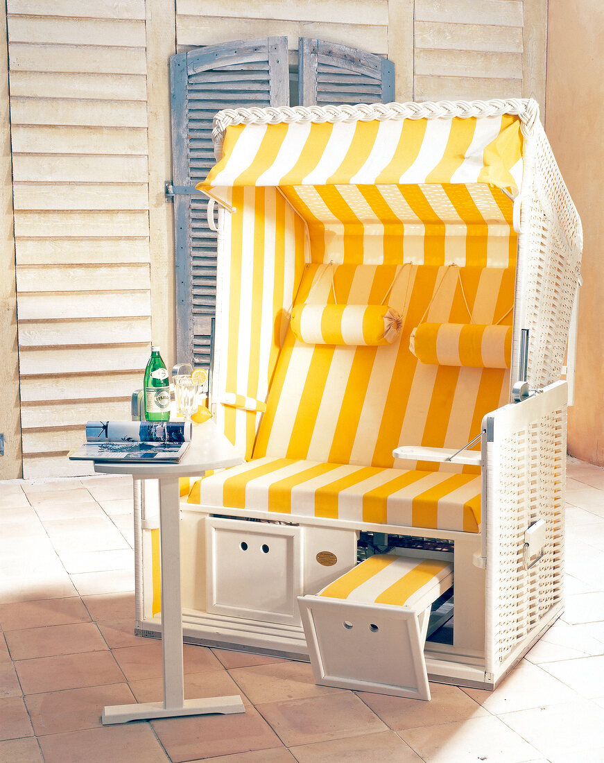 Yellow and white striped beach chair with side table