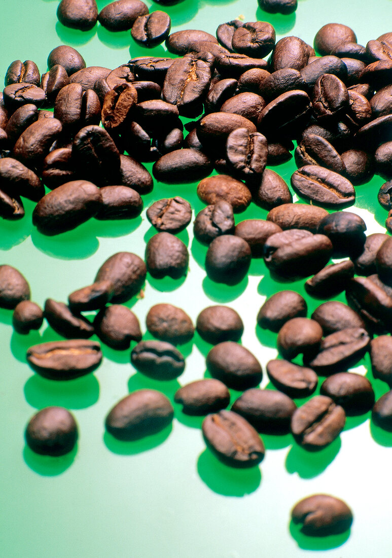 Close-up of coffee beans on green background