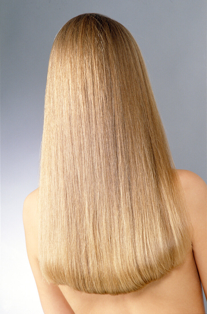 Frau versteckt ihr Gesicht hinter langem, blondem Haar