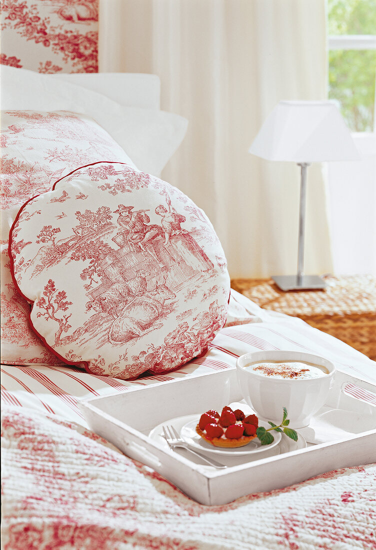 Detail von einem Schlafzimmerbett, Kissen mit Motiv, Frühstück