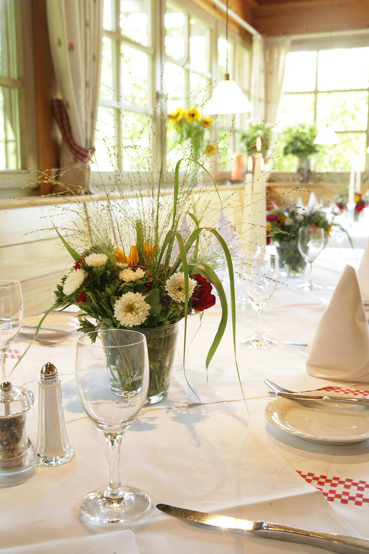 Close-up of flower bouquet in vase on laid table in restaurant, Germany