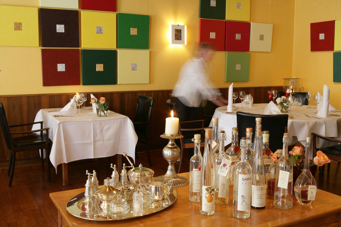 Various glasses and bottles on table in restaurant, Germany